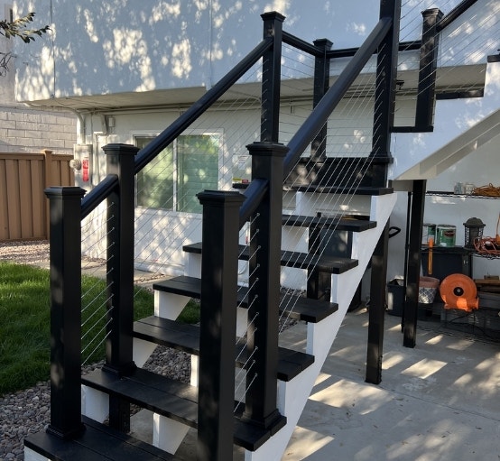 Black and white stairs with black deck railing.